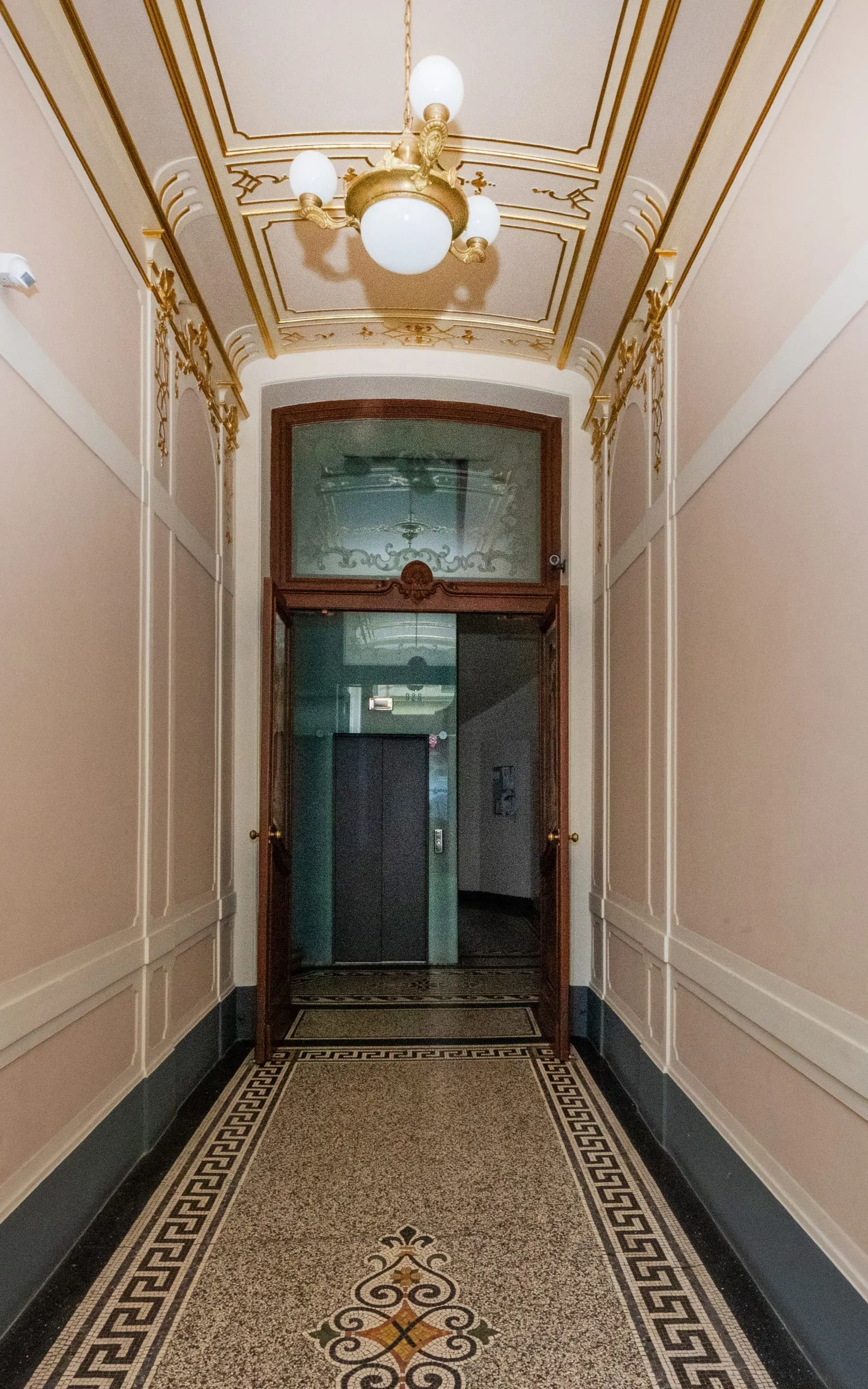 Entrance hall with a mosaic floor, stained glass and brass lamps