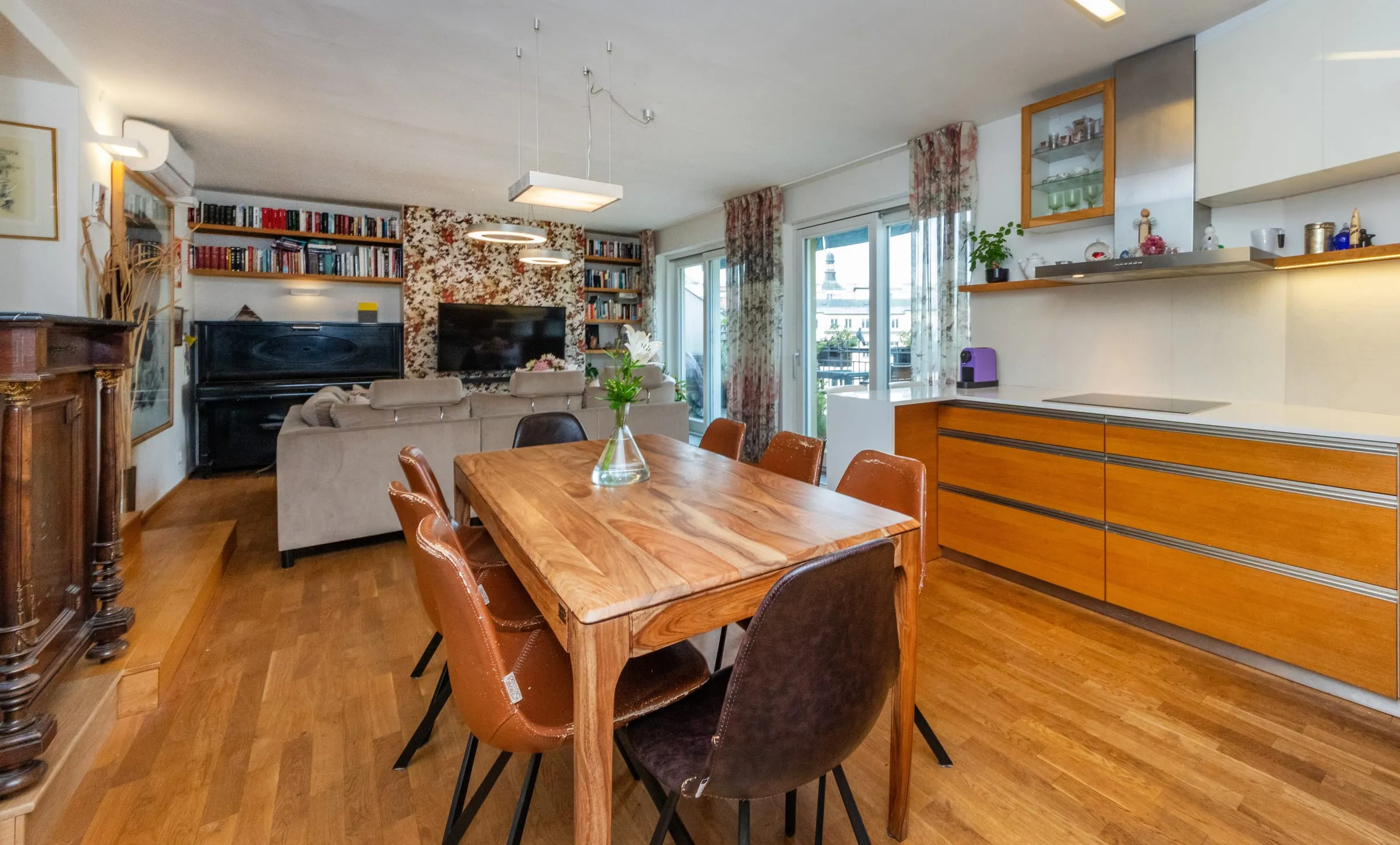 Downstairs living room with a wooden dining table and open kitchen