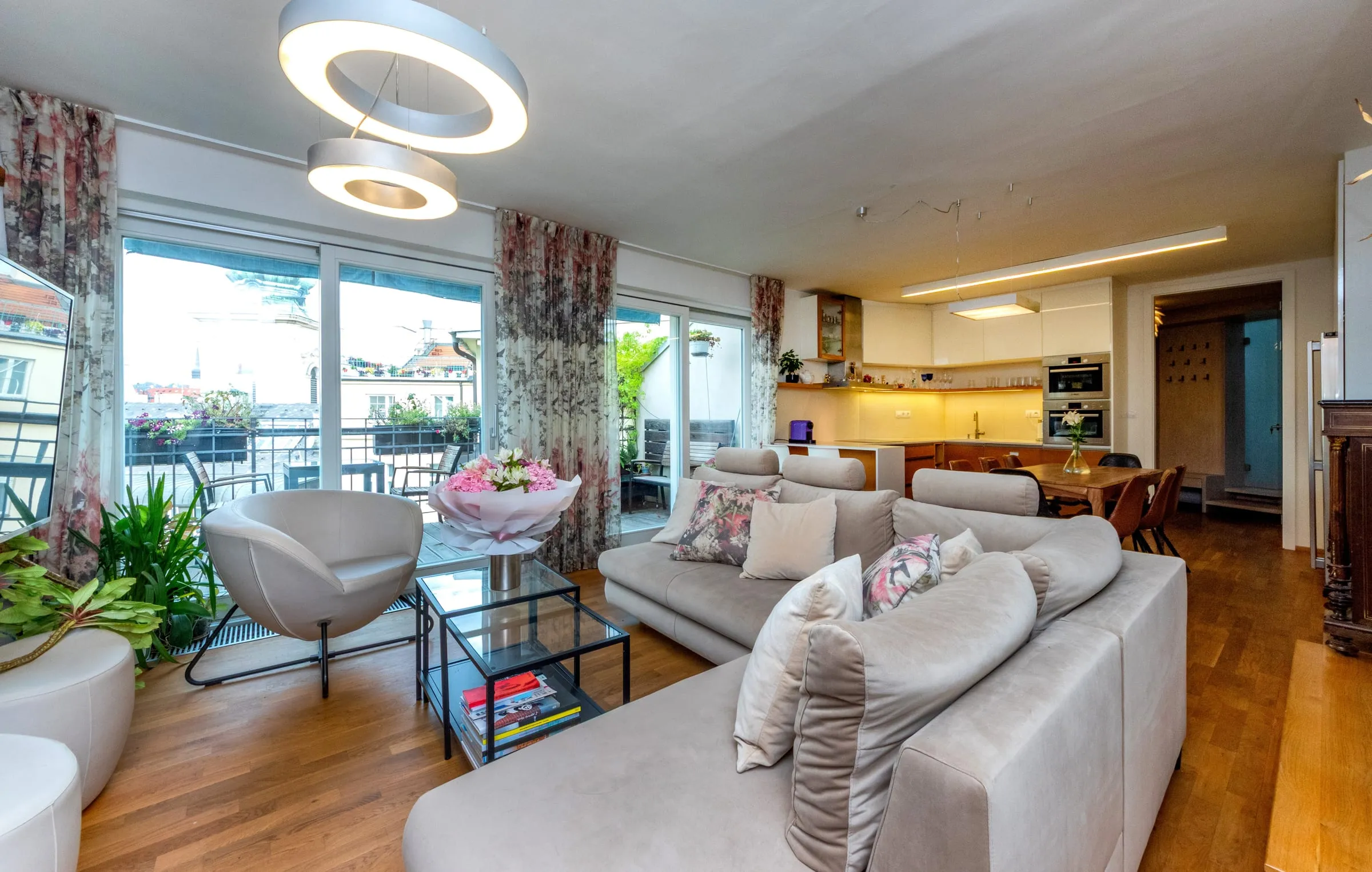 Living room sofas with the terrace and Old Town rooftops behind