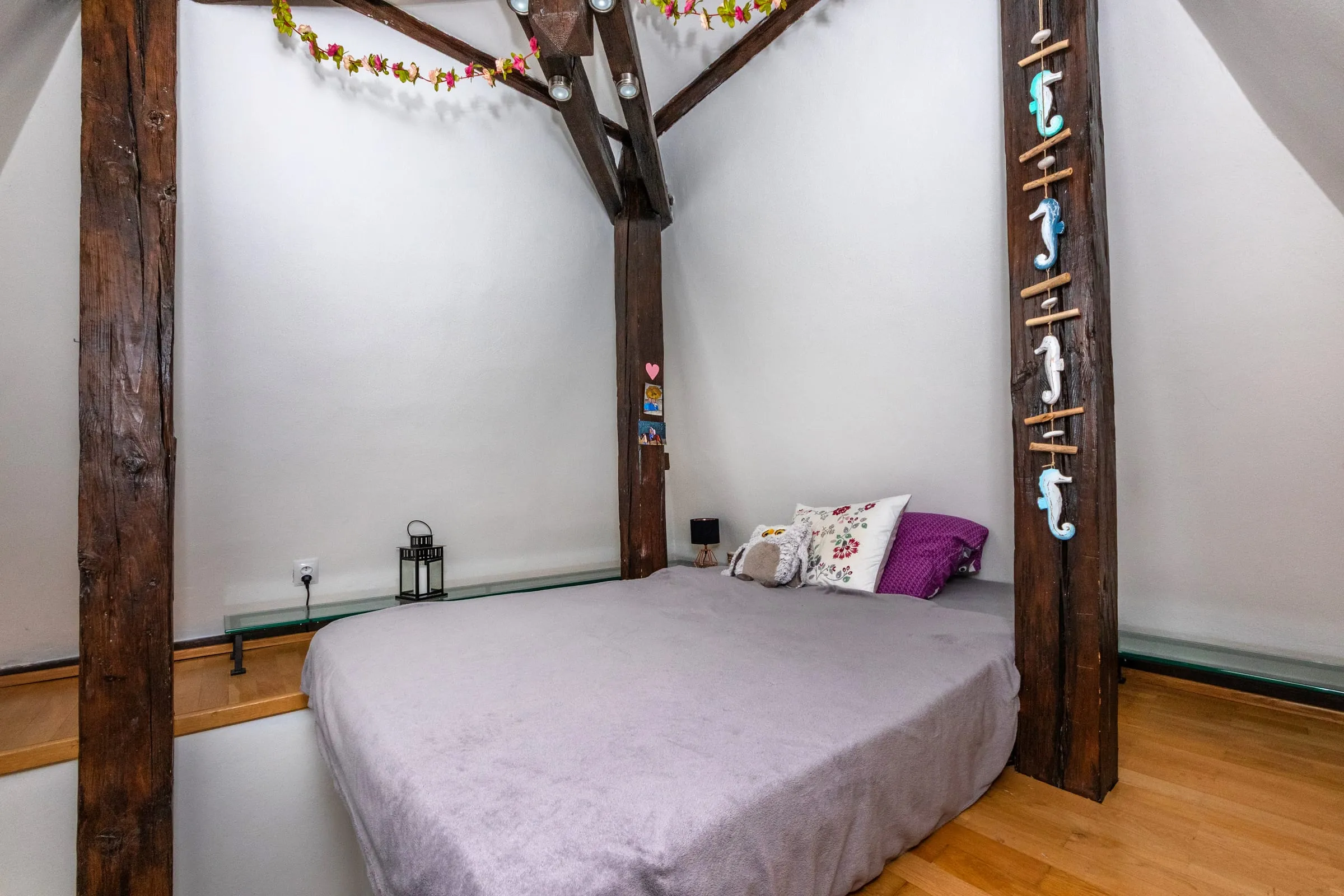 Bed in the tower between old timber roof beams